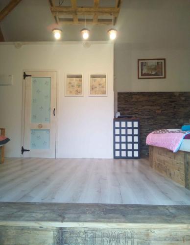 a room with a bed and a wooden floor at Pokojíky na Větrné in Malšín
