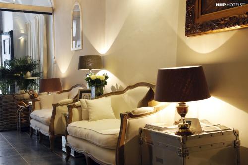 a living room with chairs and a table with a lamp at Lesar Hotel Angel - Member of Hip Hotels in Ljubljana
