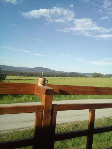 a wooden fence with a cup on top of it at Pokojíky na Větrné in Malšín