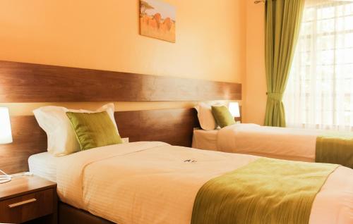 a hotel room with two beds and a window at LIA Hotel & Training Centre in Nairobi