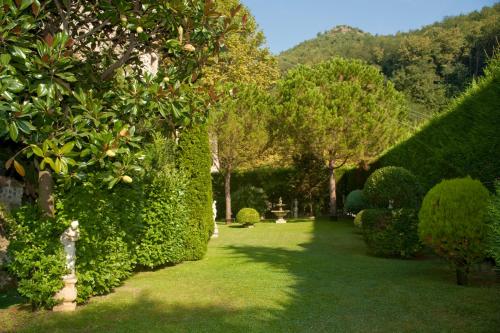 a garden with green hedges and trees and grass at Hotel Scapolatiello in Cava deʼ Tirreni
