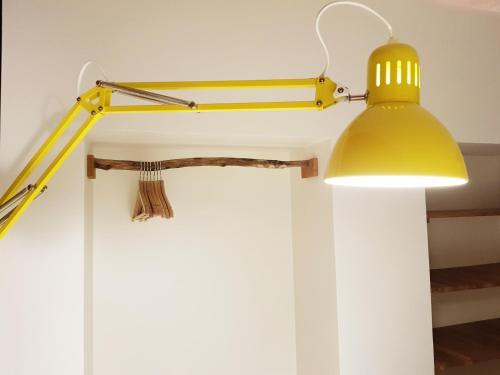 a yellow lamp hanging on a wall next to a wall at Vakantiehuis ABEL in Dilsen-Stokkem