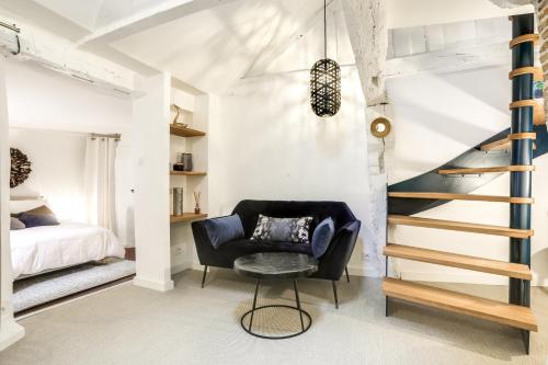 a bedroom with a black chair and a staircase at LE CELESTIN - Centre Historique - in Rennes