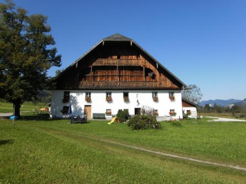 a large white barn with a thatched roof at Pilznerhof in Strobl