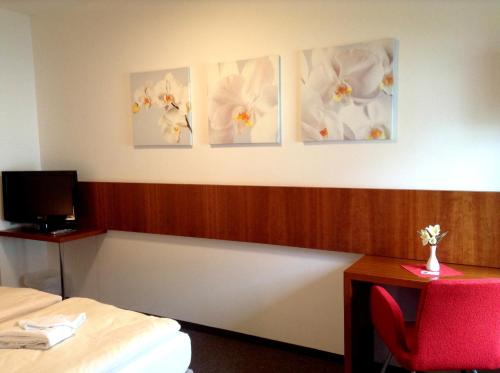 a room with three pictures of flowers on the wall at Thalinger Hof in Kronstorf