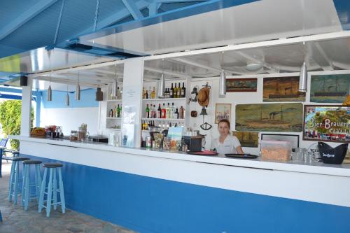 a man sitting at a counter in a bar at Galeana Beach Hotel in Platanes