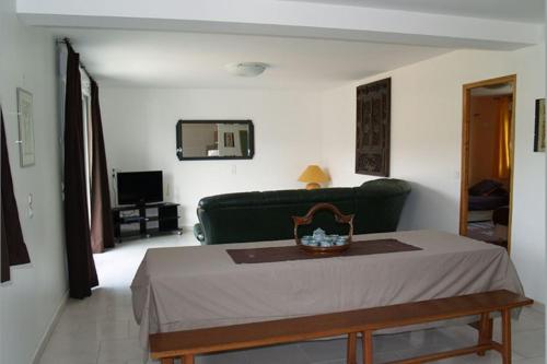 sala de estar con sofá verde y mesa en Gîte des Mesanges, en Haybes