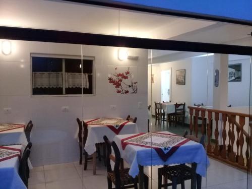 a dining room with two tables and chairs at Pousada La Sierra in Campos do Jordão