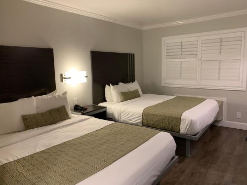 a hotel room with two beds and a window at Sand Castle Inn in Seaside