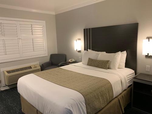 a hotel room with a large bed and a chair at Sand Castle Inn in Seaside