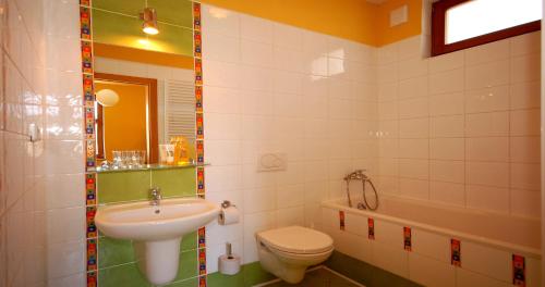 a bathroom with a sink and a toilet and a tub at Penzion Andrej in Ružomberok