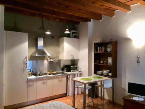 uma cozinha com armários brancos e uma pequena mesa em I Balconcini em Bérgamo