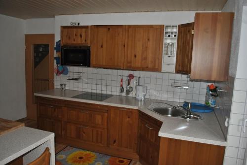 una cocina con armarios de madera y fregadero en Ferienwohnung Giessl, en Giengen an der Brenz