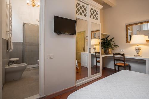 a bedroom with a bathroom with a television on a wall at Hotel Villa Maremonti in Marina di Massa