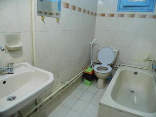 a white bathroom with a sink and a toilet at Bob Marley House Sherief Hotel Luxor in Luxor