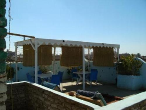 a patio with a white canopy and blue chairs at Bob Marley House Sherief Hotel Luxor in Luxor