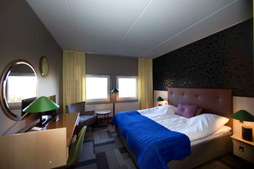 a bedroom with a bed and a desk and a chair at Hotel Lautrup Park in Ballerup