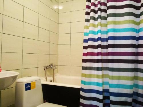 a bathroom with a tub and a toilet and a shower curtain at Квартира Лупшы 22 in Sumy
