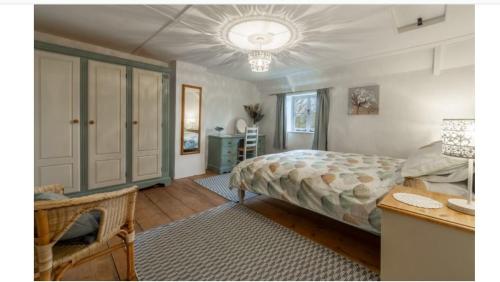 a bedroom with a bed and a dresser and a table at Lovely Cottage in North Creake