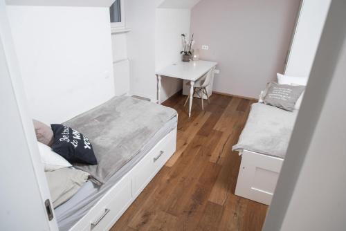 a small bedroom with a bed and a desk at Apartment Vila Pavlovski in Bled