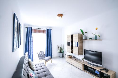 a living room with a couch and a tv at Apartamento Tejo in Cacilhas