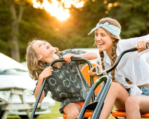 two young girls playing on a merry go roundousel at Ohakune TOP 10 Holiday Park in Ohakune