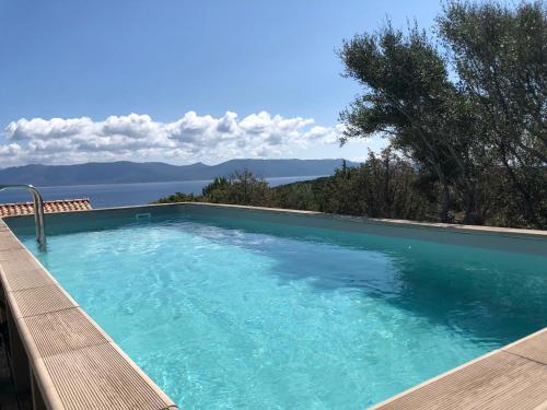 a swimming pool with a view of the water at Les Villas MarInCelu in Porto Pollo