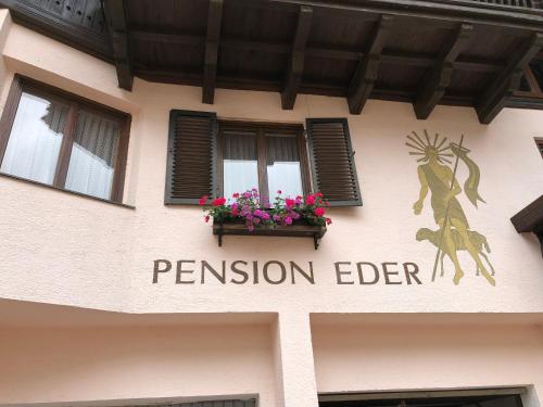 a sign for a pension elder on the side of a building at Pension Eder - Joker card included in summer in Saalbach Hinterglemm