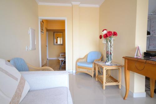 a living room with a vase of flowers on a table at Palm Beach Retreat in Palm-Eagle Beach