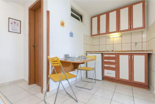 a kitchen with a table and chairs in a room at Apartments Rosa in Kaprije