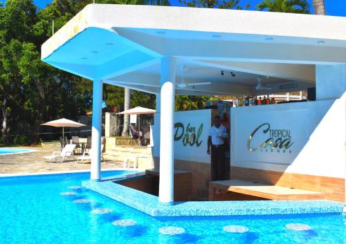 a man standing next to a swimming pool next to a pool at Tropical Casa Laguna in Cabarete