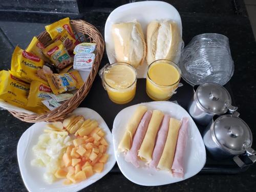 uma bandeja de comida com cachorros quentes, pão e sumo de laranja em Motel Morumbi (Adults Only) em Taboão da Serra