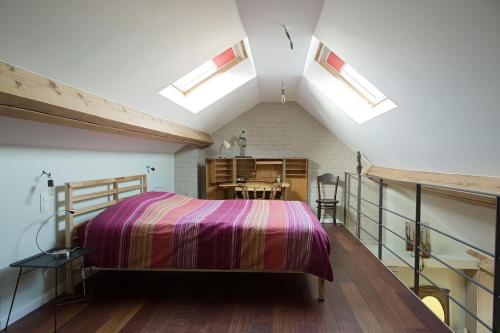 a attic bedroom with a bed and skylights at B&B La Chambre de Plume in Brussels