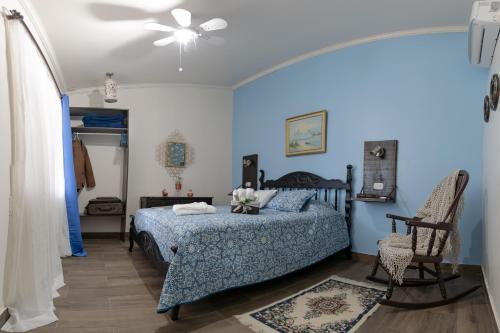 - une chambre avec un lit et un ventilateur de plafond dans l'établissement Alice y Juancito Boutique Hotel, à Alajuela