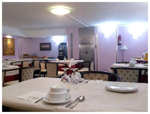 a dining room with a white table and chairs at Hotel Arha Santander in Santander
