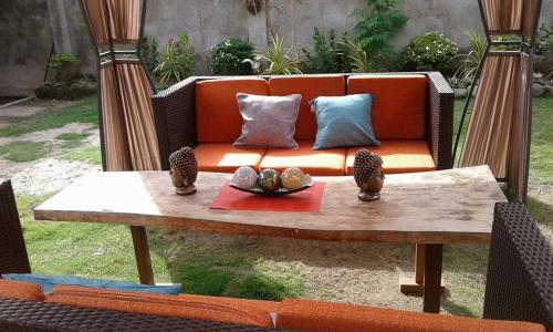 an orange couch with pillows on top of a table at Anabelle Residence in Dumaguete
