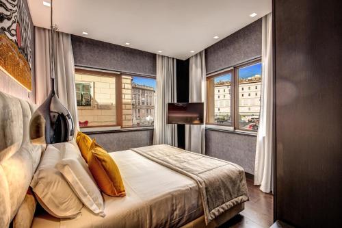 une chambre d'hôtel avec un lit et deux fenêtres dans l'établissement Prassede Palace Hotel, à Rome