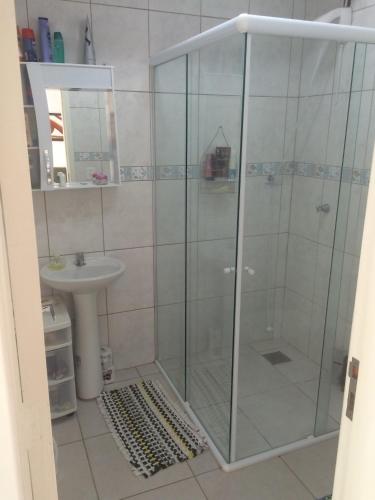 a shower with a glass door in a bathroom at Casa Aconchego e Sossego Imbé in Imbé