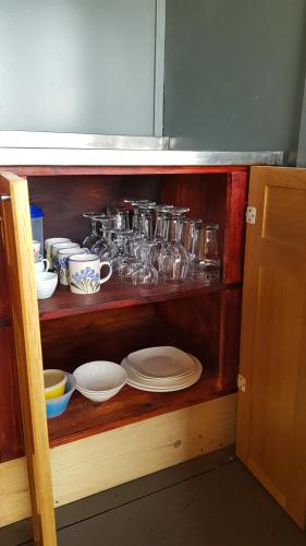 a shelf with a bunch of dishes on it at Pilot's Cabin, El Mirador Airfield in Champagne Valley