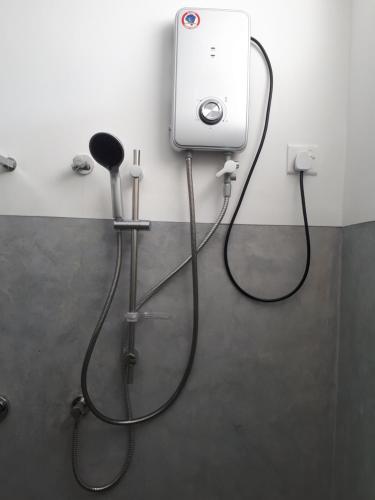 a shower in a bathroom with a hose hooked up to a wall at Lake View Villa in Mirissa