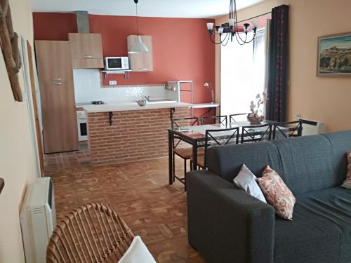 西古恩薩的住宿－Los Balcones - Alojamiento Rural en Sigüenza，客厅以及带沙发和桌子的厨房。