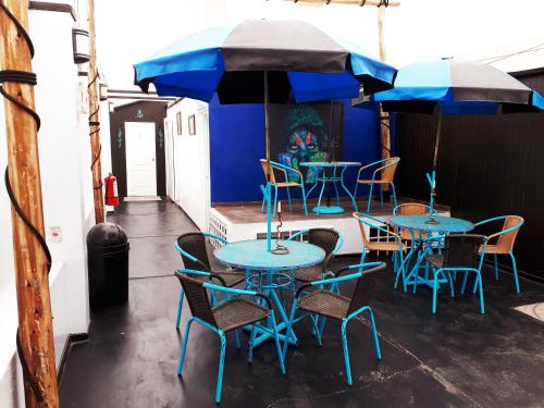 um grupo de mesas e cadeiras com guarda-sóis em Blue Shark Apartments em San Bartolo