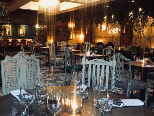 a dining room with tables and chairs with wine glasses at The Belmore in Sale