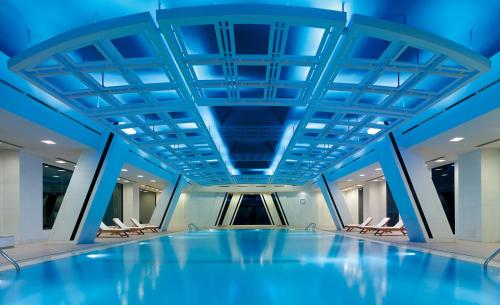 uma piscina num edifício com tectos azuis em China World Hotel, Beijing em Pequim