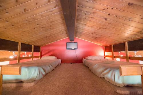 2 Betten in einem Zimmer mit roter Wand in der Unterkunft Brettelberg Slopeside Condos C9 in Carbondale