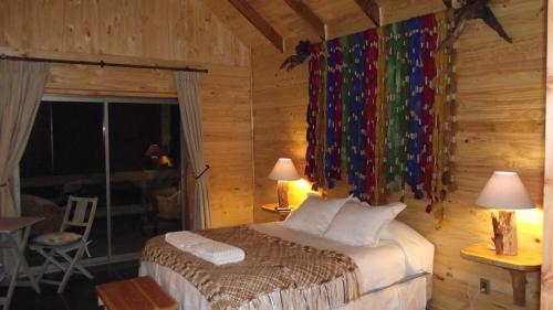 a bedroom with a bed in a log cabin at Cabañas Emporio de la Meme in San José de Maipo