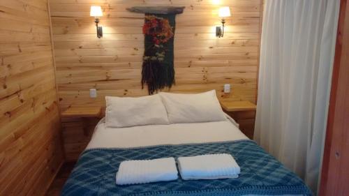 a bedroom with a bed with two pillows on it at Cabañas Emporio de la Meme in San José de Maipo
