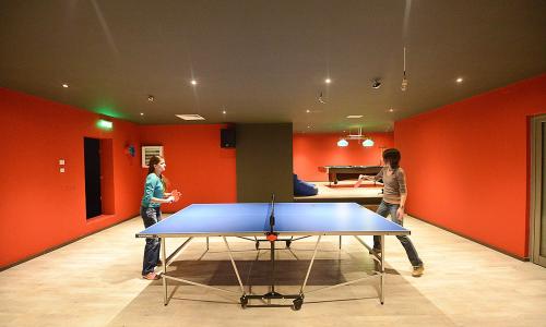 two women standing in a room with a ping pong table at Hotel Escalade in Poiana Brasov