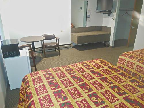 a hotel room with a bed and a table and chairs at Amber Inn Motel in Bliss