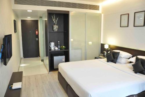 a bedroom with a large white bed in a room at Comfort Inn Sunset in Ahmedabad